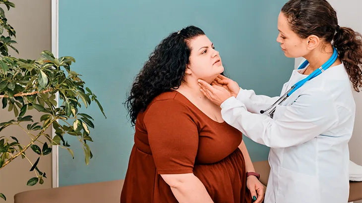 Médica com a ponta dos dedos no pescoço da paciente