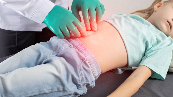 Médico apertando barriga de menina.