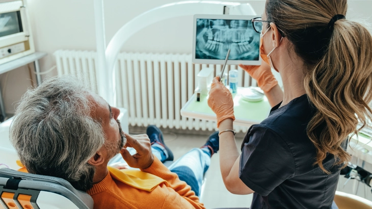 médica mostrando raio-x da boca do paciente