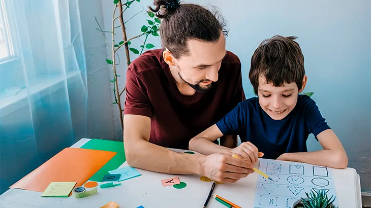 Homem com lápis ensinando menino a ler